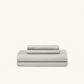 Mid-tone gray cooling sheets designed with cooling technology and moisture-wicking fabrics folded on a cream background.