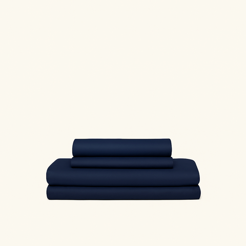 Navy blue 4-piece cooling sheets made with cooling technology and moisture-wicking fabrics folded on a cream background.