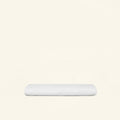A folded Slumber Cloud Core Mattress Protector - Crib on a cream background
