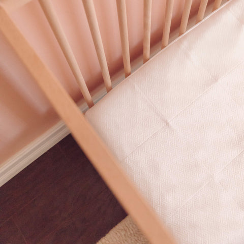 A top view of a baby's crib with a Slumber Cloud Core Mattress Protector - Crib