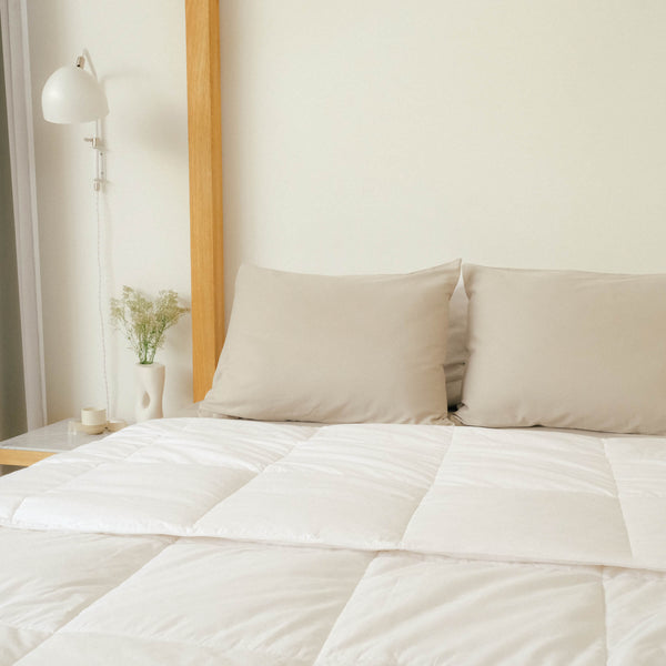A clean bedroom with Slumber Cloud Comforter and pillows